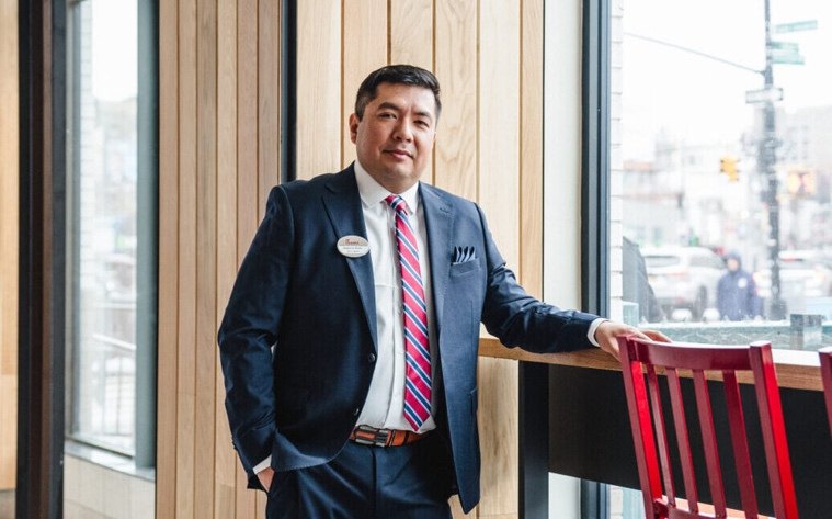 An Owner-Operator standing in a Chick-fil-A Restaurant next to a red chair