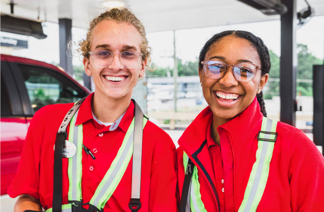 Two Team Members smiling and standing together in the Chick-fil-A Drive Thru