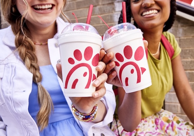 Two customers smiling and holding Chick-fil-A® milkshakes