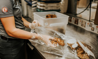 Person placing chicken strips into clear plastic